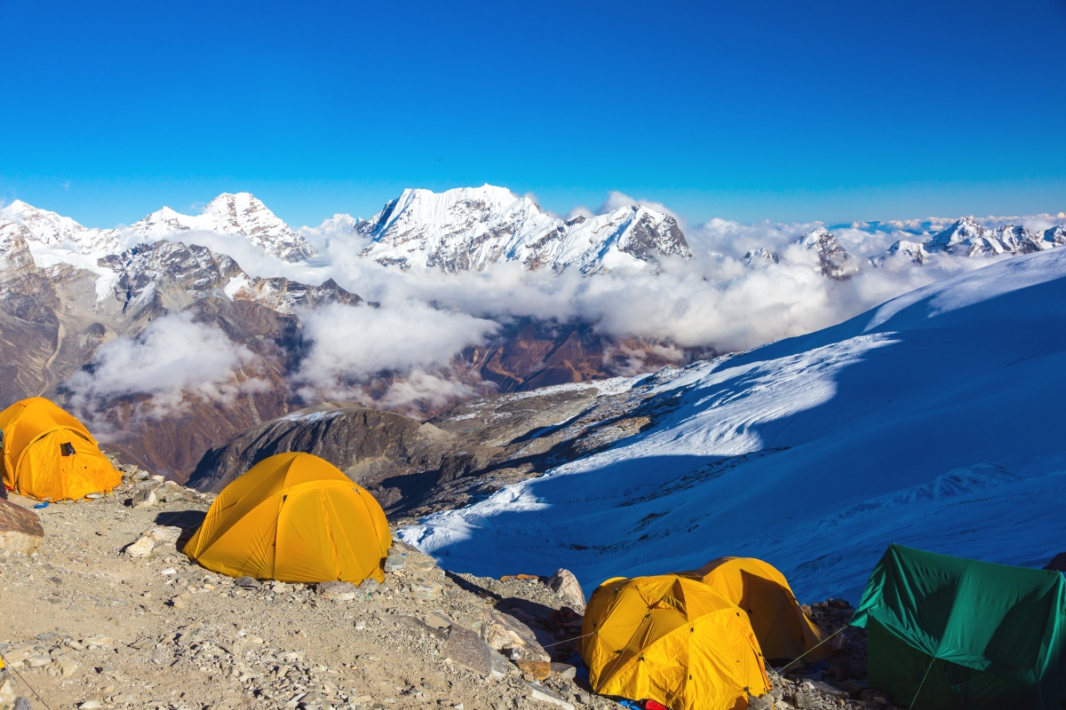 mountain view on the background with tent on the cliff